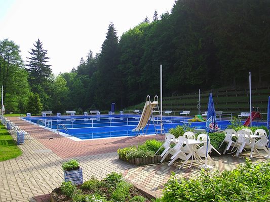 Schwimmbecken mit Rutschen und Sitzecke im Waldschwimmbad in Schönau vor dem Walde / OT Georgenthal in der Talsperrenregion (UNESCO Global Geopark Thüringen Inselsberg – Drei Gleichen)