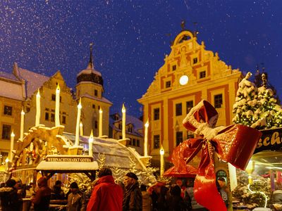 Der Weihnachtsmarkt in Gotha auf dem Hauptmarkt mit Rathaus im Schnee und Kerzen und Lichtern