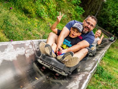 Vater mit seinem Sohn auf der Sommerrodelbahn im Funpark am Inselsberg in der Inselsbergregion im Thüringer Wald