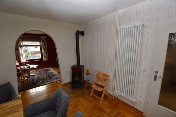 Essbereich mit Kaminofen, Holzstuhl und Durchgang zum Wohnzimmer im Ferienhaus Urban