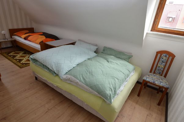 Schlafzimmer mit Einzelbett und Schlafsofa für zwei Personen im Ferienhaus Urban