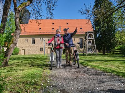 Pärchen mit zwei Fahrrädern vor Kirche in Georgenthal (Talsperrenregion) im Thüringer Wald
