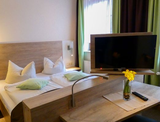 Doppelzimmer mit Doppelbett und TV in der Schlossgartenpassage – Pension „Schlossblick“ in Ohrdruf im UNESCO Global Geopark Thüringen Inselsberg – Drei Gleichen