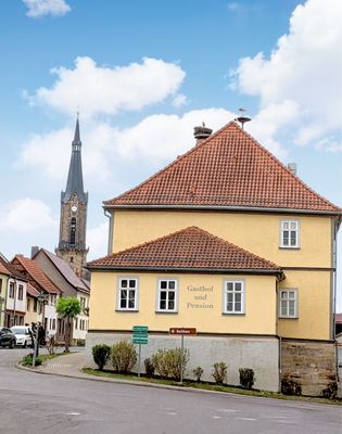 mAußenansicht mit gelber Hausfassade vom Quartier Goldener Löwe in Wechmer / Thüringer Burgenland Drei Gleichen