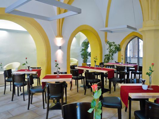 Café im Augustinerkloster in Gotha, mit Tischen, roten Tischdecken, Stühlen und Rosen (Region Gotha & Gothaer Land)