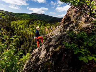 Jana Urban klettert im Lauchagrund in Bad Tabarz und blickt in einer Pause auf den Großen Inselsberg (Inselsbergregion)