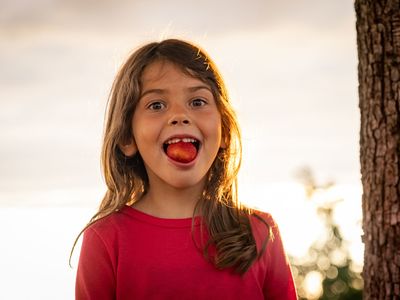 Kind im Sommer mit Erdbeere im Mund in Gotha & Gothaer Land in Thüringen