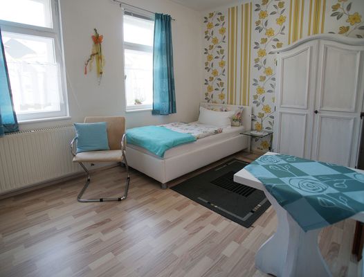 Ein Einzelbett mit Sitzgelegenheit im Hotel Villa Phönix in Friedrichroda (Inselsbergregion)