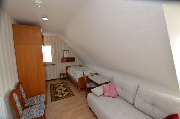Schlafzimmer mit Einzelbett und Schlafsofa für zwei Personen im Ferienhaus Urban