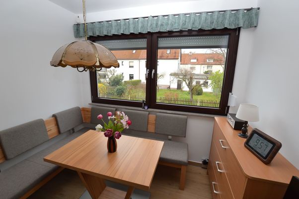Heller Wintergarten mit Holztisch und Sitzbank im Ferienhaus Urban