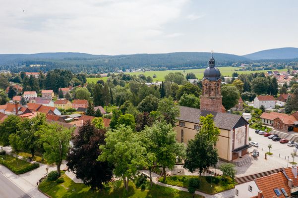 Die Lutherkirche in Tambach-Dietharz in der Talsperrenregion im Thüringer Wald aus der Vogelperspektive, umgeben von weiteren Gebäuden des Erholungsortes